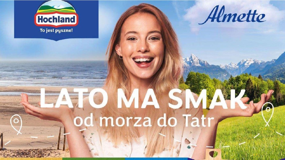 Reklama sera Almette: uśmiechnięta dziewczyna, po lewej plaża i morze, po prawej Tatry i łąka, napis „Lato ma smak, od morza do Tatr”